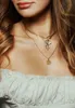 Close-up of a woman wearing layered gold necklaces. Produktbild-Vorschau