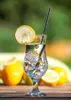A glass of iced water with lemon and a straw, with lemons in the background. Náhled obrázku produktu