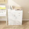 A white cabinet with two doors and two drawers, topped with books and a radio. Náhled obrázku produktu