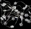 A close-up shot of a string of snowflake-shaped LED lights against a black background. Podgląd zdjęcia produktu