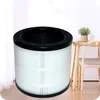 A cylindrical air filter is placed in front of a wooden table with a plant on it. Náhled obrázku produktu
