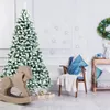 A festive Christmas scene with a flocked artificial Christmas tree, a wooden rocking horse, gifts, and a chair with pillows. Anteprima dell’immagine prodotto