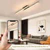 A hand holding a smartphone displaying a modern LED ceiling light in a living room setting, with the actual ceiling light visible above. Produktbild-Vorschau
