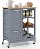 A grey kitchen cart with a wooden top, drawers, and shelves, filled with various kitchen items. Voir les images du produit