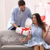 A man is giving a woman a gift on a couch. Produktbild-Vorschau