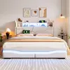 A modern bedroom with a white upholstered bed featuring LED lighting and a headboard with storage. Podgląd zdjęcia produktu