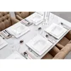 A formal dining table setting with white square plates, silverware, and wine glasses. Produktbild-Vorschau