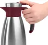 A hand is holding a stainless steel carafe with a burgundy accent. Anteprima dell’immagine prodotto