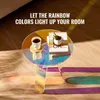 A round, iridescent coffee table with a cup of coffee and books on it, with rainbow light reflections on the floor. Anteprima dell’immagine prodotto