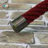 A close-up of a red rope with a bronze-colored metal end cap, set against a brick-like background. Produktbild-Vorschau
