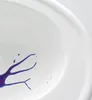 A close-up of a white sink with purple paint splatters. Produktbild-Vorschau