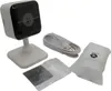 A white security camera with its accessories laid out on a white background. Produktbild-Vorschau