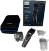 A Philips hair clipper and its accessories are laid out on a white background, along with its packaging. Produktbild-Vorschau