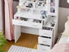 A white vanity table with drawers and a cabinet, filled with makeup and accessories, placed next to a pink curtain and a bed. Voir les images du produit