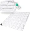 A folded duvet is shown stacked on top of itself, with a separate, unfolded duvet laid out below it. A tag with certifications is attached to the folded duvet. Produktbild-Vorschau