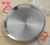 A paella pan is shown from a top-down diagonal view, resting on a tiled surface. Produktbild-Vorschau