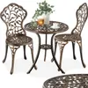 A bistro set with two chairs and a table, decorated with a leaf motif.