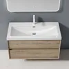 A modern wall-mounted bathroom vanity with a white sink and a light wood-toned cabinet with two drawers, set against a gray wall. Anteprima dell’immagine prodotto
