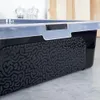 A close-up view of the side of a black storage container with a gray patterned texture and a transparent lid. Náhled obrázku produktu