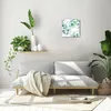 A living room with a sofa, plants, and a clock on the wall. Produktbild-Vorschau