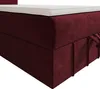 A close-up view of a burgundy box spring bed with a white topper. Produktbild-Vorschau