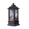 A black Halloween-themed lantern with a skeleton and pumpkin scene inside. Produktbild-Vorschau