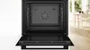An open black oven with the interior visible, set against a neutral background. Produktbild-Vorschau