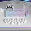 A white gaming setup including a keyboard, mouse, controller, and headphones, with a bubble-like wrist rest in the foreground. Podgląd zdjęcia produktu