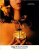 A woman's décolletage with a snake around her neck, holding a bottle of Fidji perfume. Anteprima dell’immagine prodotto