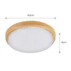 A round, flush-mount ceiling light with a wooden frame and a textured, translucent diffuser. Produktbild-Vorschau