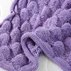 A close-up view of a textured purple knitted blanket. Anteprima dell’immagine prodotto