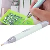 A hand is using a diamond painting pen to pick up a rhinestone from a green tray. Voir les images du produit