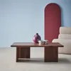 A coffee table with decorative items in a room with a light blue wall and a burgundy arch. Produktbild-Vorschau