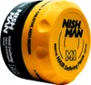 A close-up, angled shot of a Nishman M1 Matte Defining Argan Paste hair product container. Náhled obrázku produktu