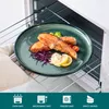 A plate of cooked salmon with sides is being placed into an oven. Voir les images du produit