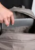 A hand is placing a laptop into a backpack. Anteprima dell’immagine prodotto