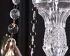 Close-up of a crystal chandelier with hanging glass beads and metal rings. Náhled obrázku produktu