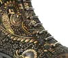Close-up view of a black boot with a gold ornate pattern and silver eyelets. Produktbild-Vorschau