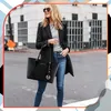A woman is posing on a street with a large black leather tote bag. Produktbild-Vorschau