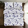 A top-down view of a bed with blue and white floral patterned bedding. Produktbild-Vorschau