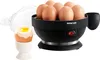 A Sencor egg cooker with several eggs inside, and one egg in an egg cup in the foreground. Produktbild-Vorschau