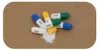 Several capsules are scattered on a brown surface, with one capsule open and spilling its powder. Produktbild-Vorschau