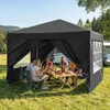 People are sitting around a table under a black canopy tent, enjoying a meal outdoors. Anteprima dell’immagine prodotto
