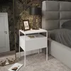 A bedside table next to a bed in a bedroom. Náhled obrázku produktu