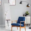 A full-length mirror stands next to a blue armchair in a room with a dresser and a floor lamp. Náhľad obrázku produktu