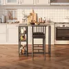 A modern kitchen scene featuring a bar stool and table set, with kitchen appliances and cabinets in the background. Náhľad obrázku produktu