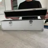 A person is holding the lid of an open aluminum case, revealing its padded interior. Produktbild-Vorschau