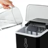 A hand is pouring water from a clear pitcher into a black ice maker. Náhled obrázku produktu