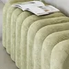 A close-up of a green upholstered bench with a book on top. Produktbild-Vorschau