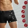 A man wearing black boxer shorts with various feature icons pointing to the product. Produktbild-Vorschau